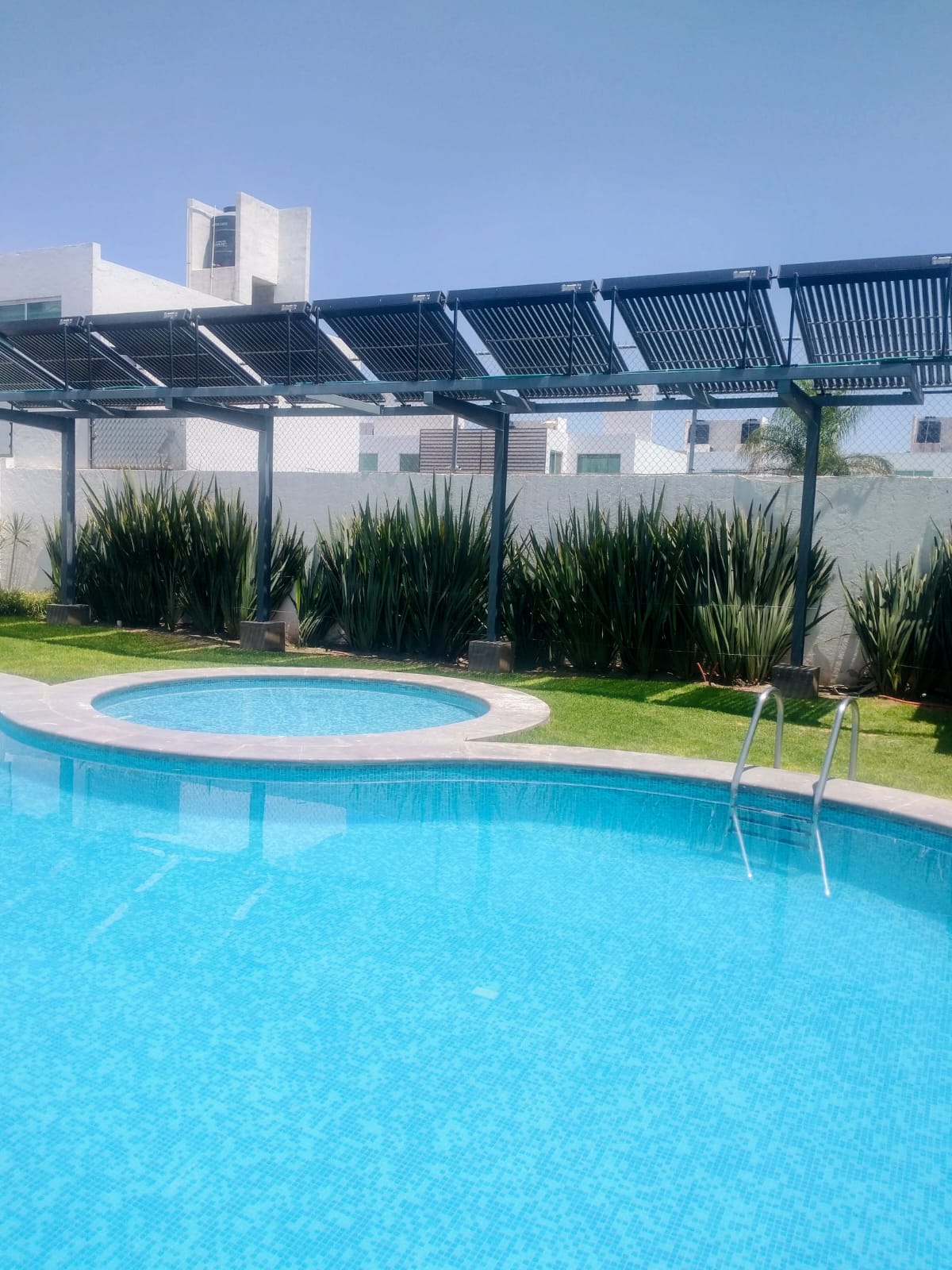 Sistema de calentamiento solar instalado junto a una alberca residencial